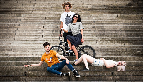 Four young people in urban clothing on park steps